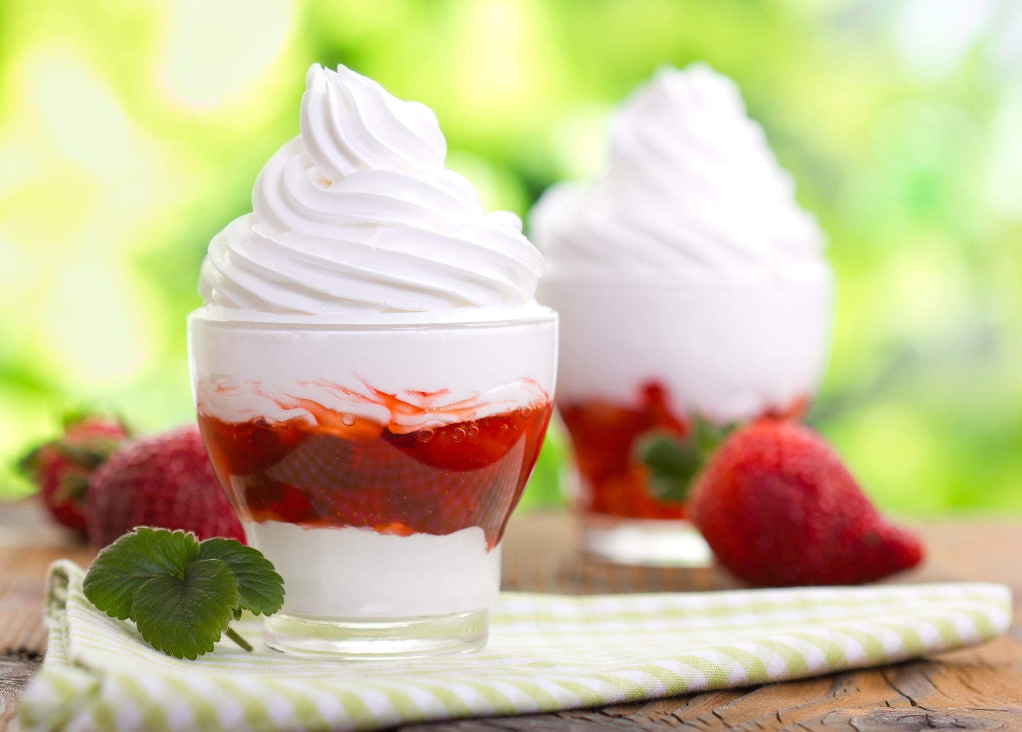 A delicious strawberry cheesecake topped with whipped cream