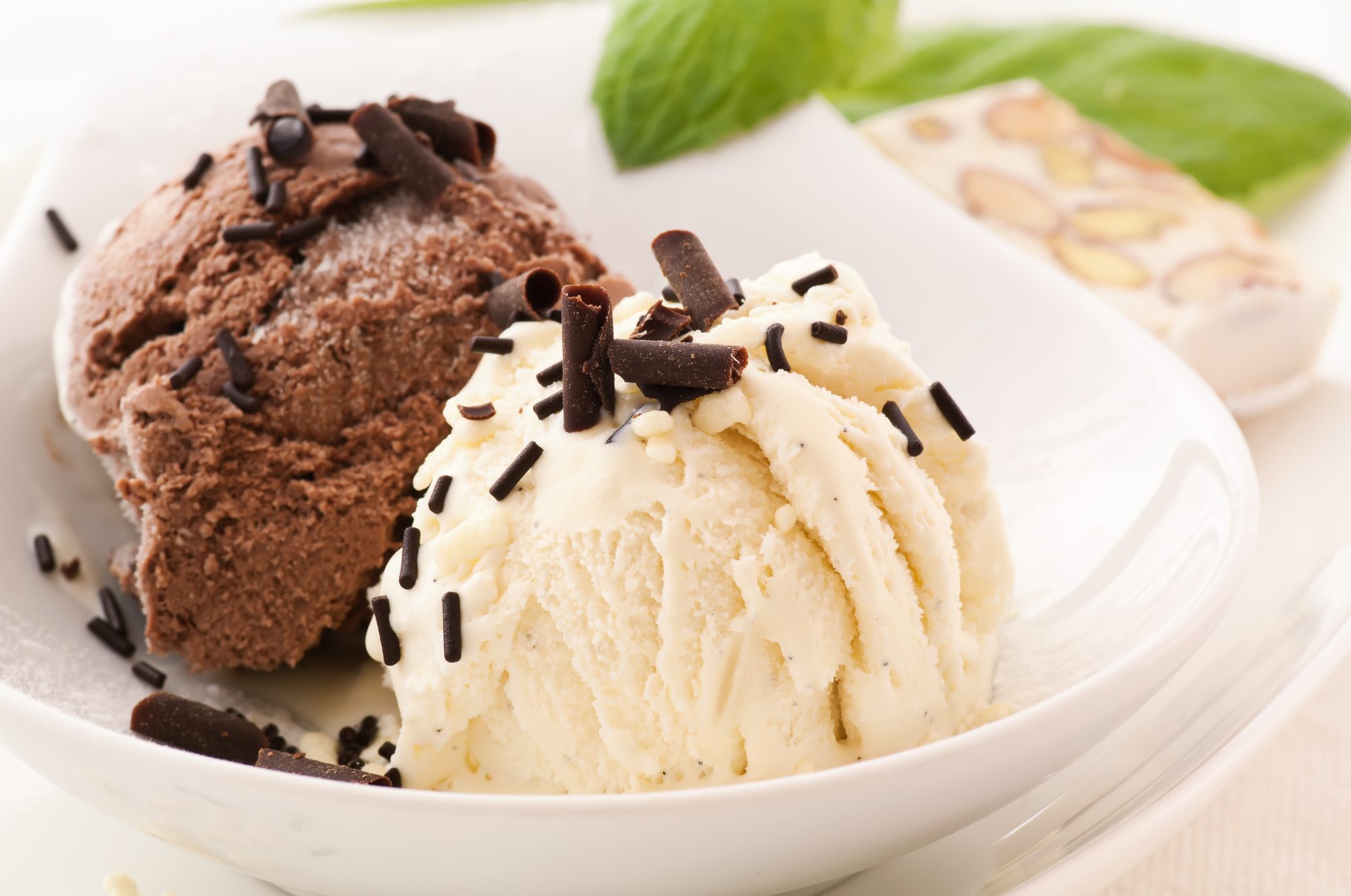 Two scoops of chocolate ice cream topped with nuts